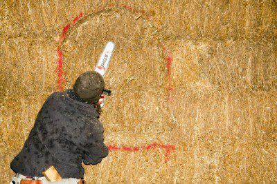 Cutting a niche in a straw bale wall with a chainsaw