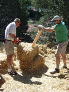 two men cutting a straw bale