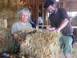 Happy people cutting a straw bale