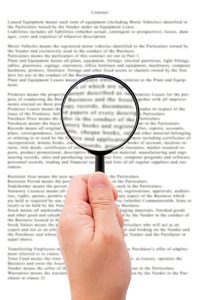 Hand holding magnifying glass reading document