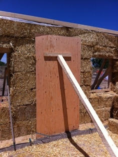 Plywood braced against a load bearing straw bale wall