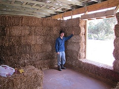 Man in front of a straw bale wall at the eco farm stay