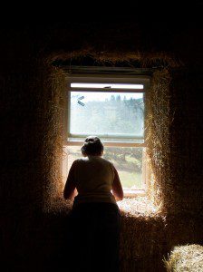 woman shaping straw bale wall