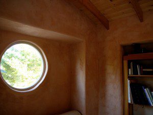 round window straw bale cabin
