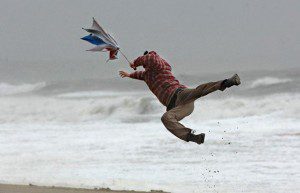 man and umbrella blown away by wind